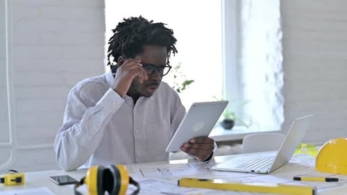 Failure African Engineer with Loss on Tablet in Office