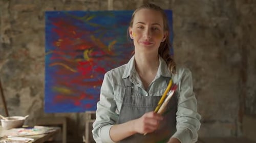 Young Artist Smiling in Front of Her Painting