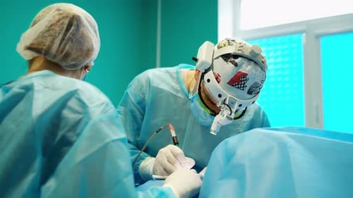 Hospital Operating Room. Doctor in gloves holding medical instrument during operation