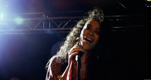 Female Singer Performing Passionately on Stage at Night