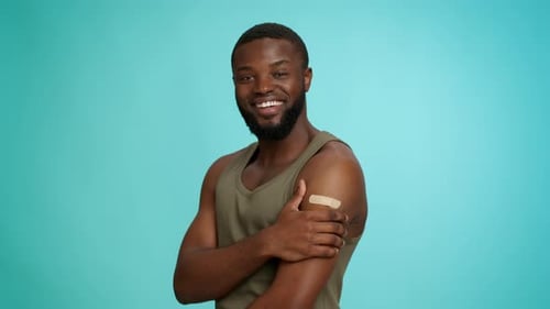 Man Smiling After Vaccination with Bandage on Arm