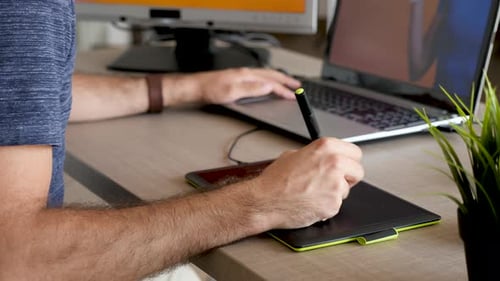 Man Using Tablet and Stylus for Digital Art