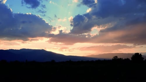 Dramatic Sunset Clouds Over Distant Mountains