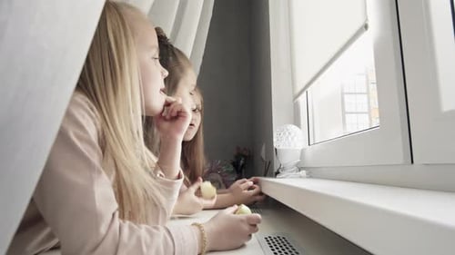 Three Girls Enjoy Apples by the Window