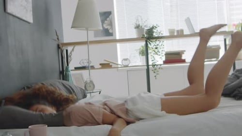 Young Woman Falling on Bed at Home and Sleeping