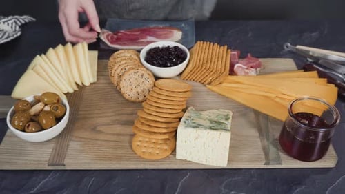 Disposer du fromage gastronomique, des craquelins et des fruits sur une planche pour obtenir un grand plateau de fromages.