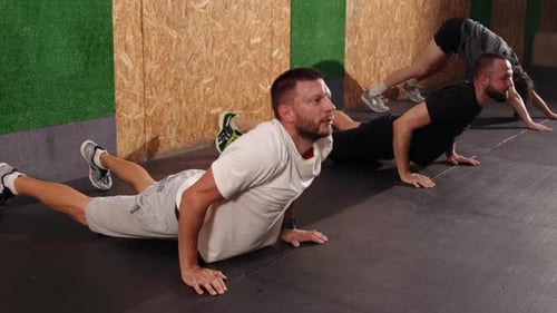Happy Men Doing Fitness Exercises Bending Forward and Stretching