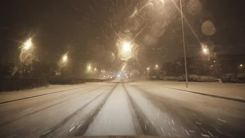 By car on a snowy road in a winter city