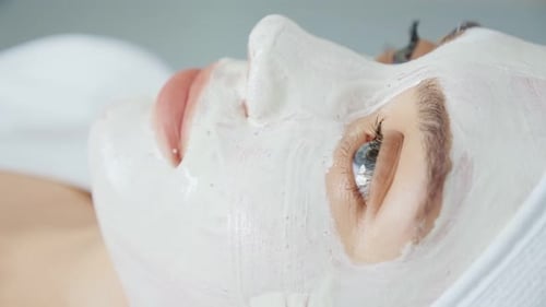 Woman Doing White Mask on Her Face in Wellness Spa Salon