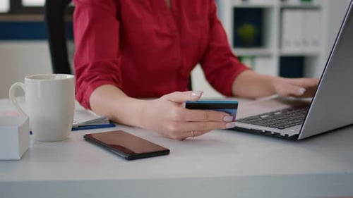 Woman Uses Laptop with Credit Card in Office