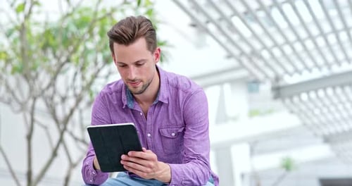 Man Using Tablet Outdoors in an Urban Setting