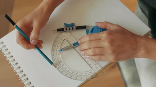 Hands Drafting with Compass and Protractor on Paper