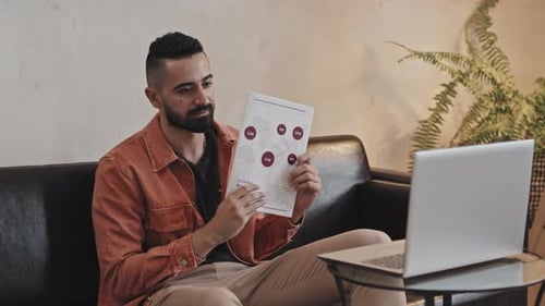 Man Presents Data via Video Conference from Couch