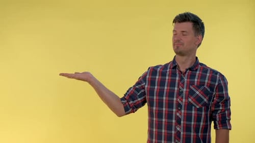 Man Presenting Space in Front of Yellow Background