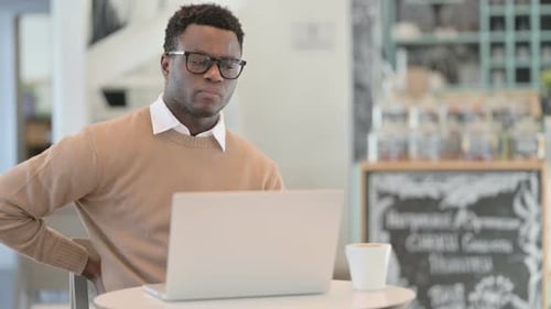 Man uses Laptop and Experiences Back Pain