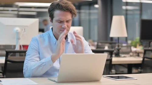 Stressed Man Working on Laptop in Office