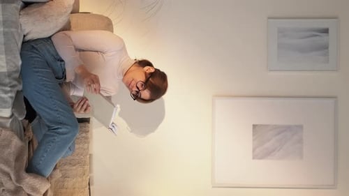 Woman Reading Book on Couch at Home