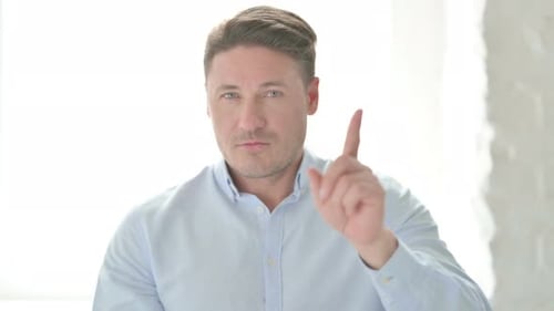 Serious Man Raising Index Finger in Warning