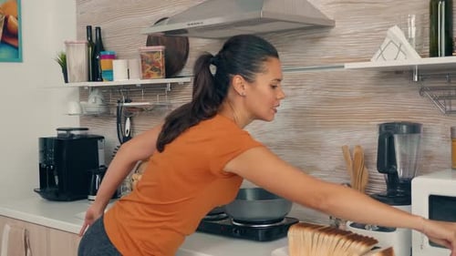 Woman Cooking Eggs and Toast in Kitchen