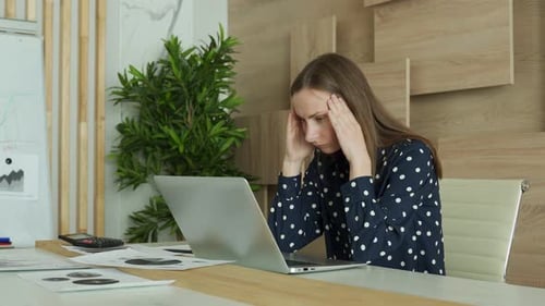 Stressed Woman Works at Laptop in Office