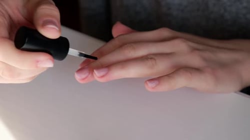 Woman Applying Clear Nail Polish at Home