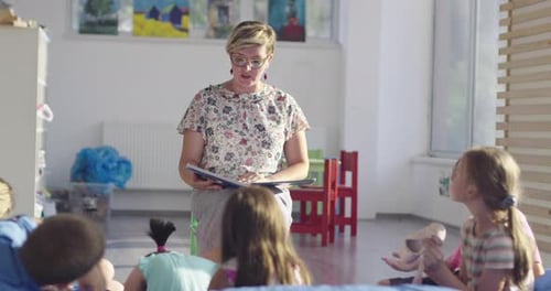 Teacher Reading a Book to Kids in Elementary School