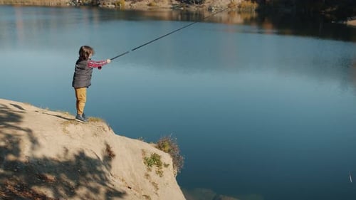 Adorable Kid Wearing Casual Clothing Fishing in River with Rod on Summer Day