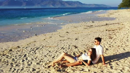 Young couple sunbathe on perfect island beach trip by transparent sea with bright sandy background o
