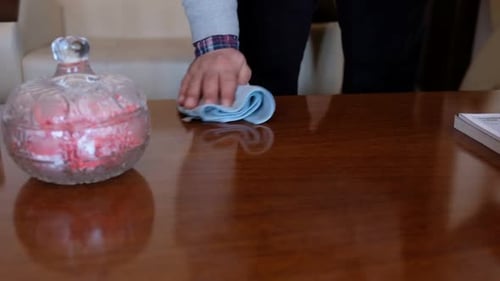 Hand Cleaning Glossy Table With Cloth