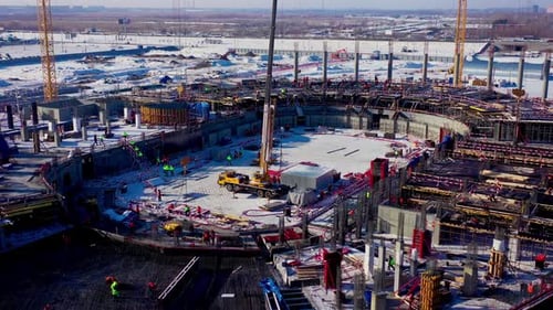 Building Process of Sports Stadium with Cranes and Employees