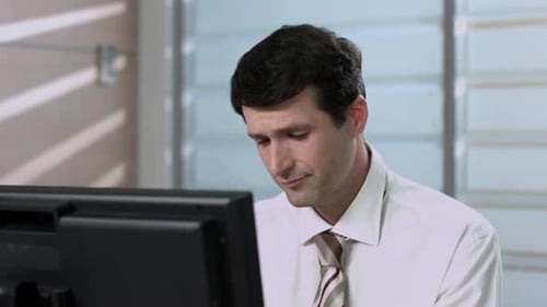 Tired Man Rubbing Eyes at Office Desk