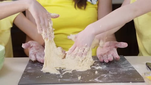 Pizzateig mit Kinderhänden aus nächster Nähe kneten. Kinder Hilfe ihrer Mutter beim Kochen