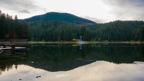 Puesta de sol de otoño en el lago de montaña con coloridos árboles en el bosque
