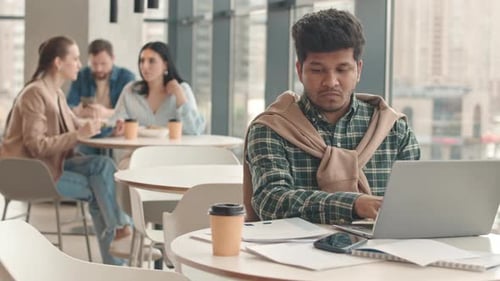 Freelancer Working on Laptop in Cafe
