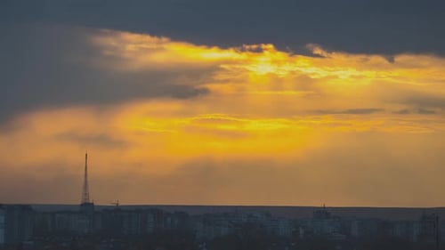 Golden Sunrise Over City Silhouette and Cloudy Sky