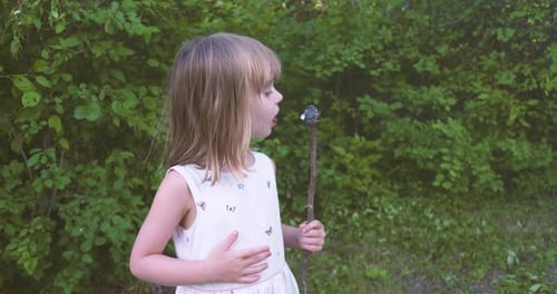 Girl Licking Marshmallow on Stick Outdoors