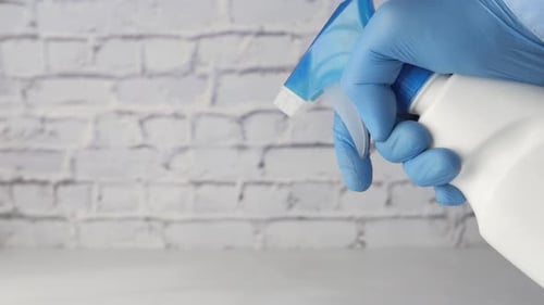 Spraying Disinfectant with Blue Glove in Close Up