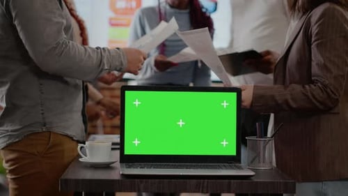 Workmates with Papers Using Green Screen on Laptop