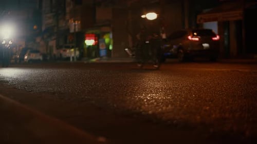 Nahaufnahme in der Nacht Tropfen von Sommer- oder Herbstregen fallen auf den Asphalt in der Stadt und verwandeln sich in einen großen