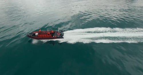 Aerial View of the Red Speed Boat with Two People on It Rushing Over the Turquoise Water.