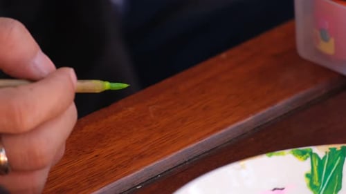 Artist Painting Fruit and Leaf on Red Paper