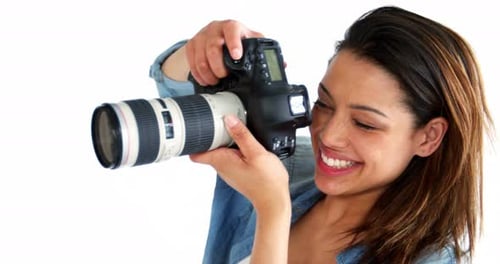 Woman Smiling While Holding Camera in Studio