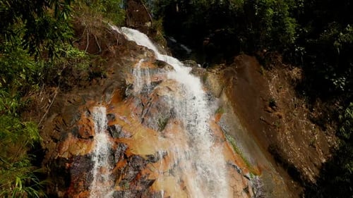 Tropical Waterfall Cascading Down Rocky Hillside