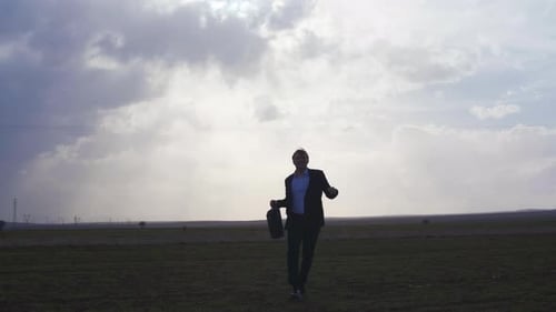 Geschäftsmann springt vor Freude auf dem Feld.