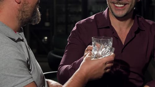 Men Toasting with Whiskey in Dark Bar