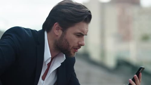 Serious Businessman Using Mobile Phone for Video Call on Street
