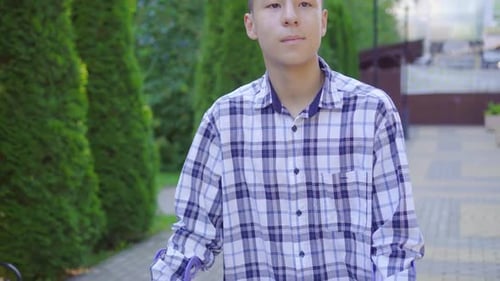 Young Asian Man with Broken Leg on Crutches Walking in Park