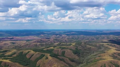 Aerial View of Rolling Hills and Cloudy Sky