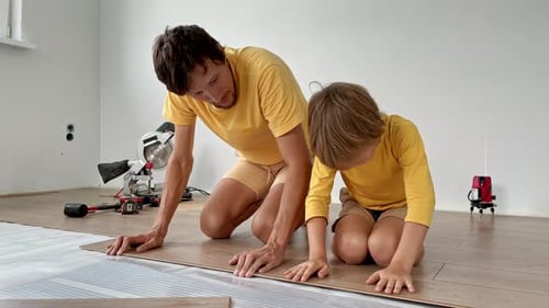 Father and Son Installing Laminate Flooring Together