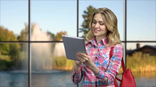 Woman with Tablet Device by Large Window